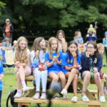 a group of vegan children sat on a bench at the vegan kids festival